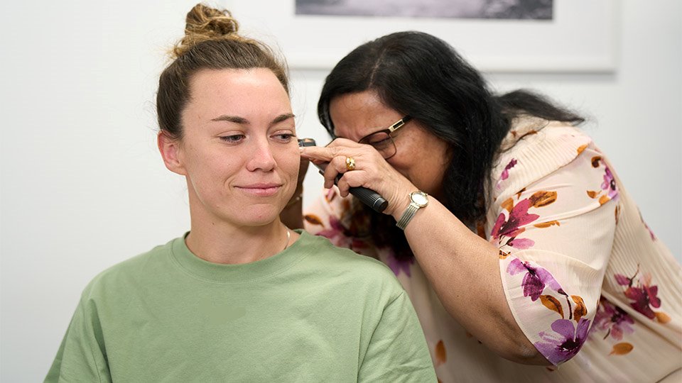 audiologist performing ear wax removal procedure