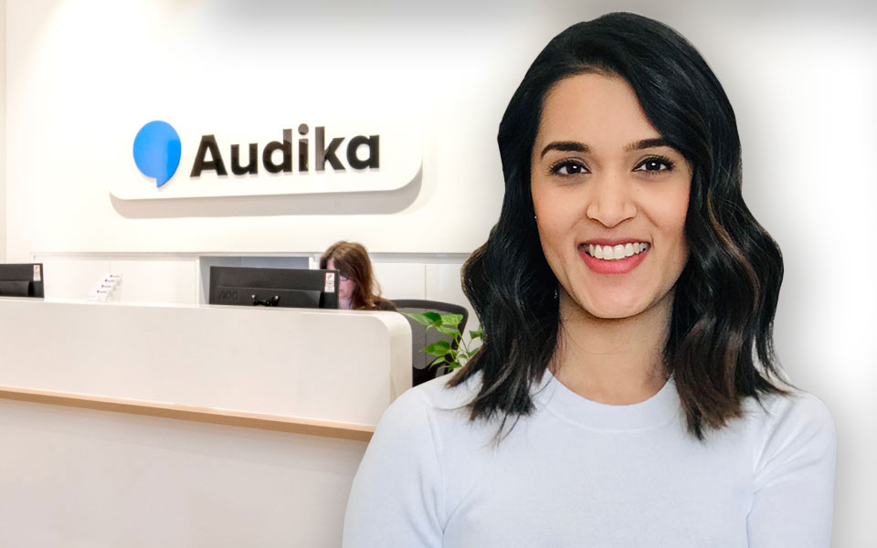 Audika hearing care professional at a clinic reception desk