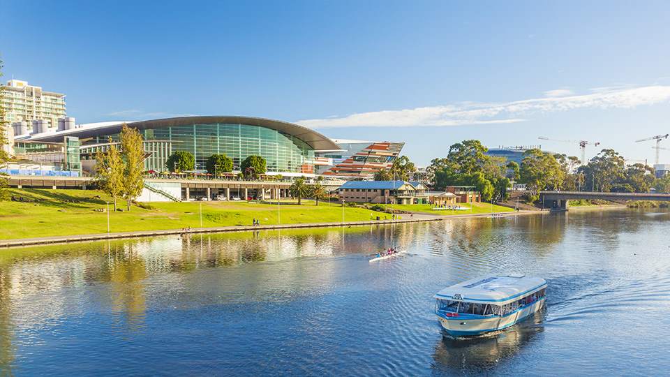 Audiologist and woman sharing a laugh in a modern hearing clinic setting.