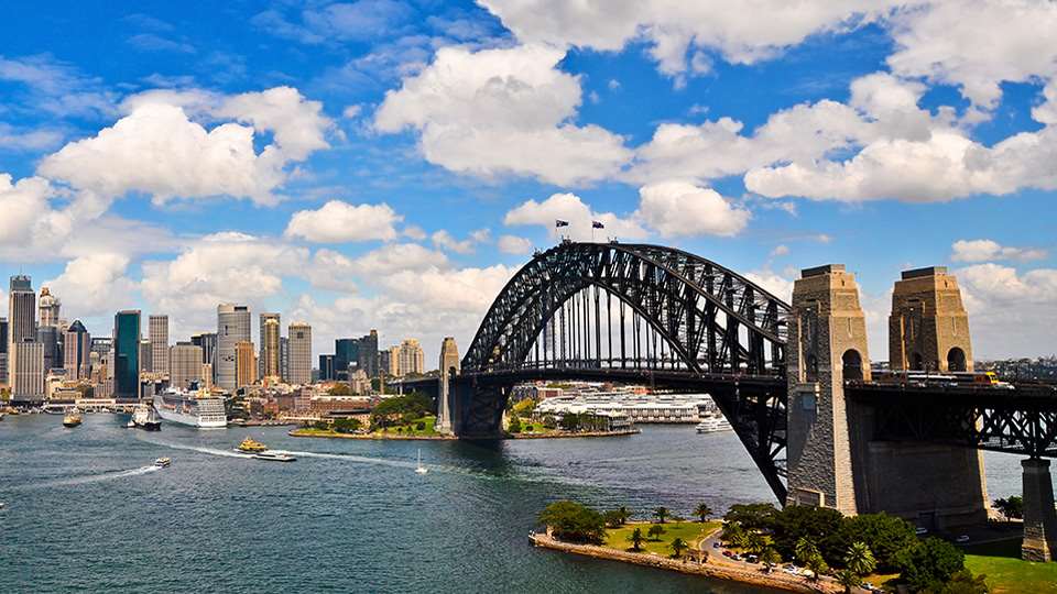 Sydney Harbour Bridge with the city skyline in the background on a sunny day.