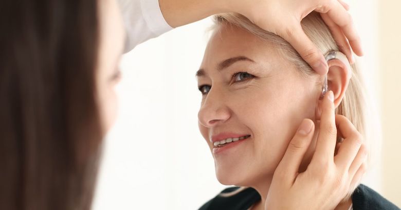 Woman having hearing aid fitted by Audiologist