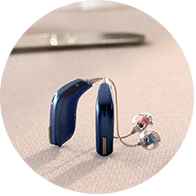 blue modern hearing aids with transparent earpieces placed on a table