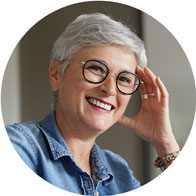 woman with short gray hair adjusting hearing aid