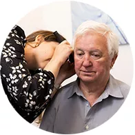 audiologist performing hearing examination on a senior patient