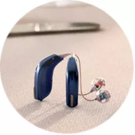 blue modern hearing aids with transparent earpieces placed on a table
