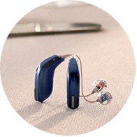 blue modern hearing aids with transparent earpieces placed on a table