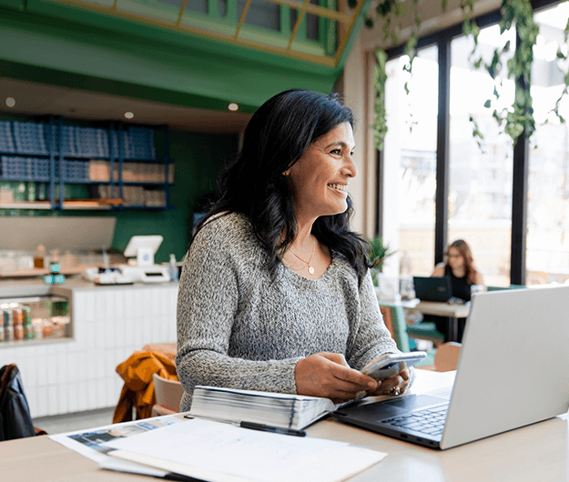 woman-working-at-laptop-using-phone