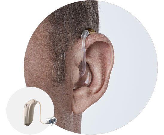 Behind-the-ear hearing aid fitted on a person’s ear, with close-up detailing of the device.