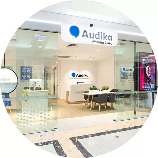 Audika Hearing Clinic storefront with a bright, modern design, showcasing a welcoming reception area and seating.