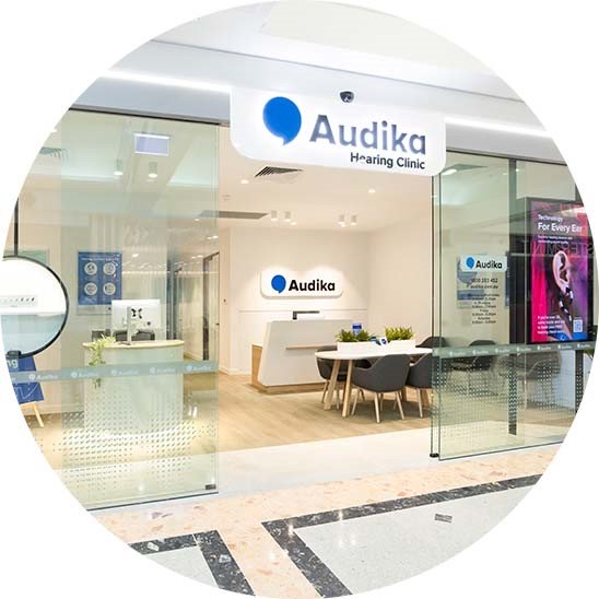 Audika Hearing Clinic storefront with a bright, modern design, showcasing a welcoming reception area and seating.