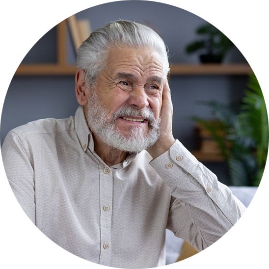 man holding ear in discomfort, indicating possible symptoms of earwax buildup