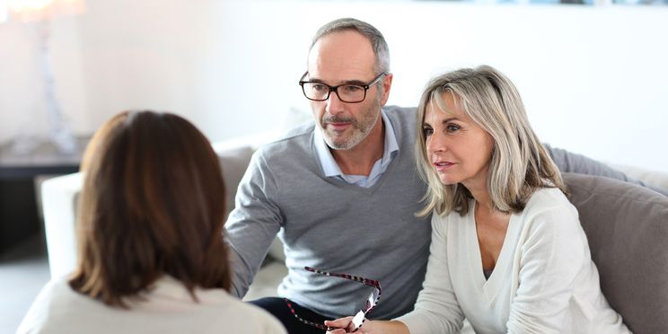 Happy couple discussing hearing care financing options with a professional