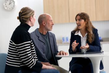 Couple_sitting_with_an_audiologist_in_clinic_having_a_discussion