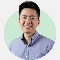 Professional man wearing a light blue button-up shirt against a light green and gray background.