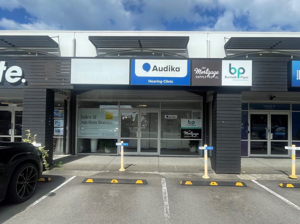 Audika Hearing Clinic in Papamoa, located within a commercial building with parking spaces in front.