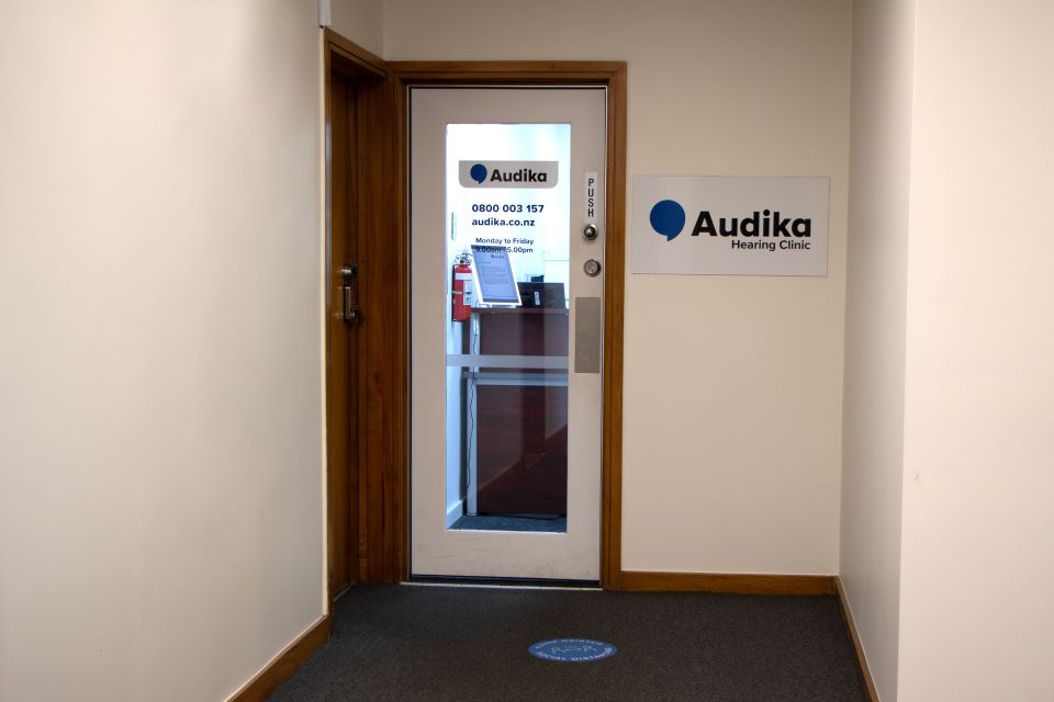 Entrance to Audika Hearing Clinic in Manurewa with clear signage displaying contact details and business hours.
