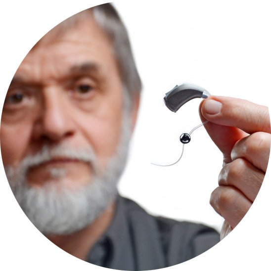older man holding a modern hearing aid