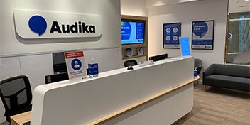 modern hearing care clinic reception area with Audika branding