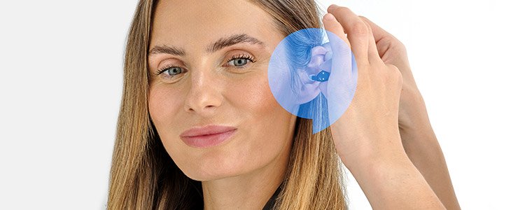 Oticon Zeal hearing aid being adjusted behind the ear.