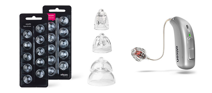 A sleek Oticon hearing aid with a wire and speaker is displayed alongside transparent ear tips of varying sizes. Multipack packages labeled ’miniFit Open 6mm’ by Oticon are positioned to the left.