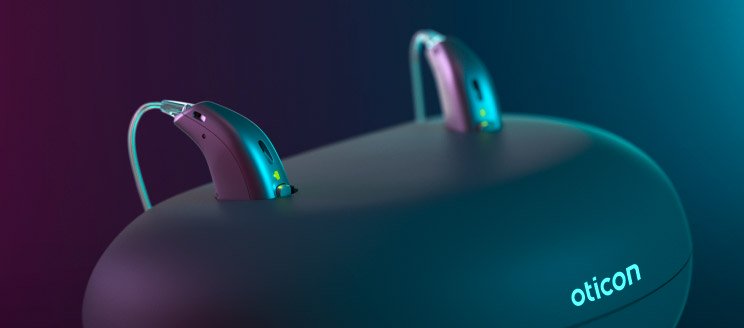 Rechargeable hearing aids on a charging station by Oticon