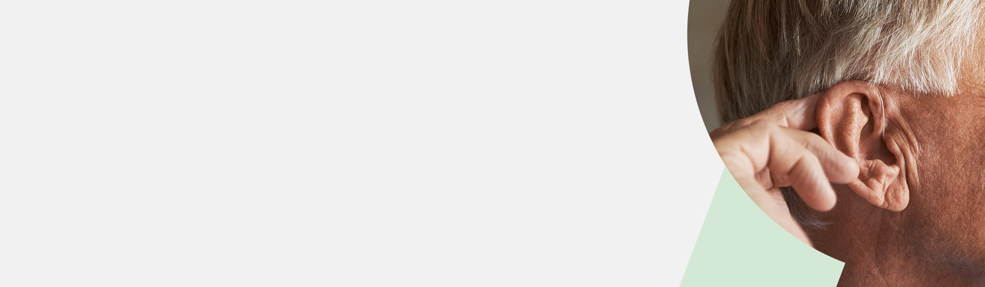 Close-up of an older man’s ear and hand, highlighting hearing health or ear care.