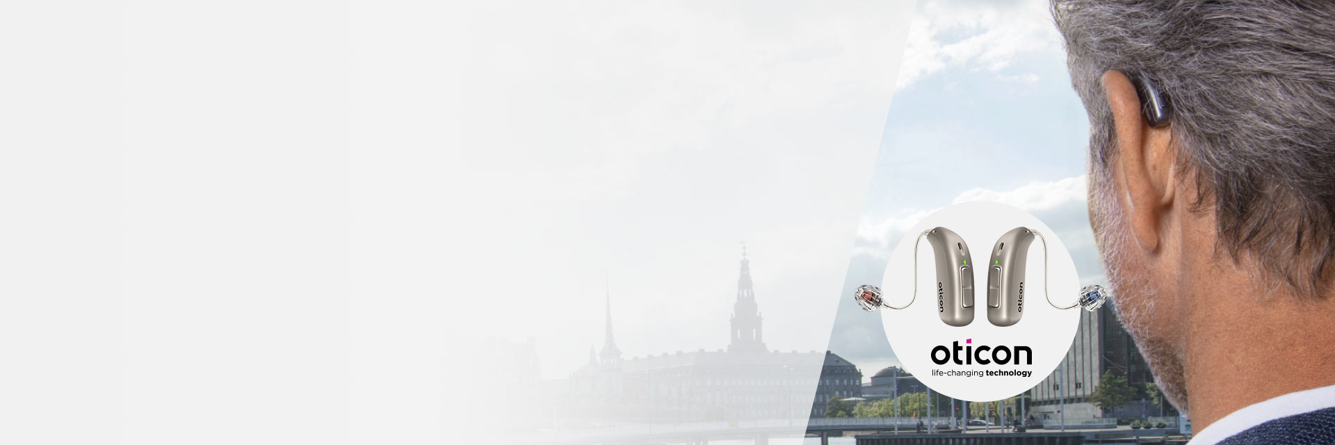 Man wearing Oticon hearing aid overlooking city skyline, with close-up of Oticon hearing aids displayed in front.
