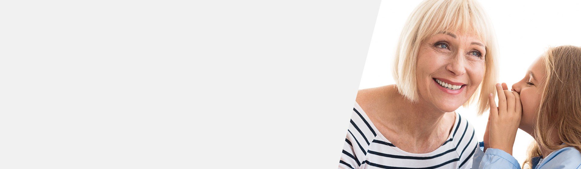 Little girl whispering to a woman wearing a striped shirt, highlighting challenges of high-frequency hearing loss.