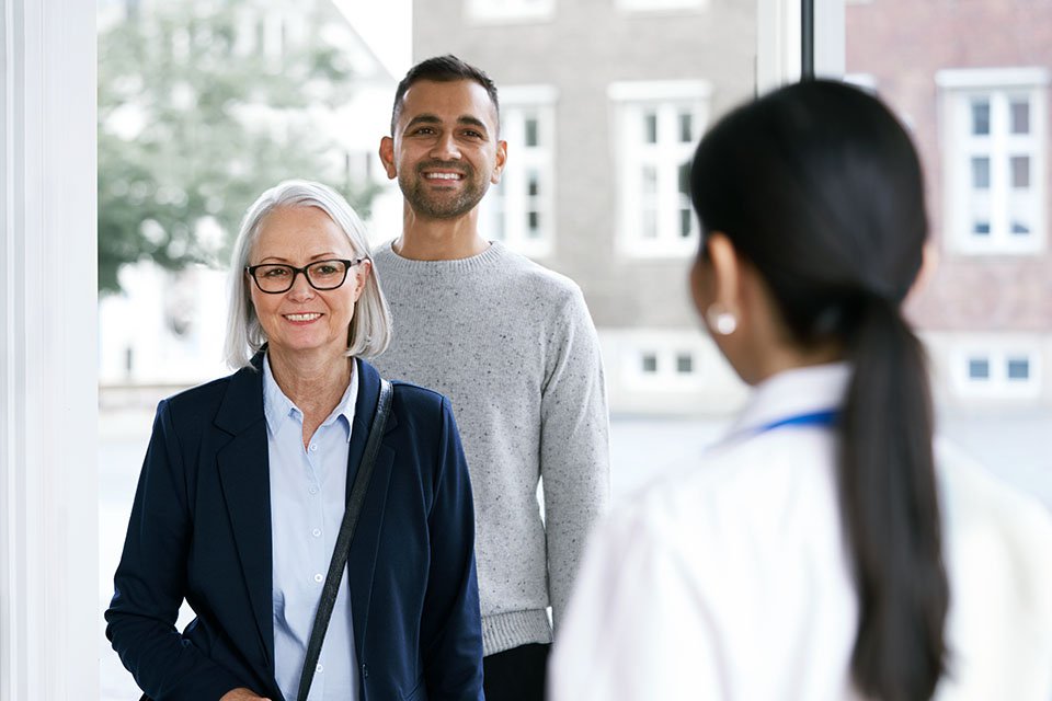 Visitors greeting a hearing care professional inside a modern hearing clinic
