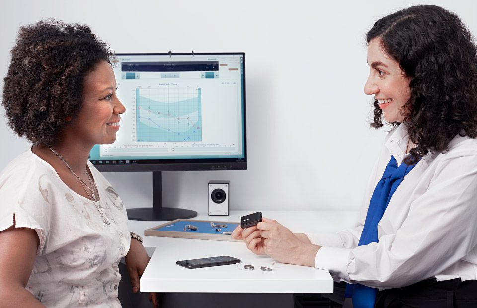 Woman consulting with a hearing care professional while exploring hearing aid options.