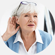 Image shows woman holding hand close to her ear