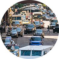 Busy city street filled with cars, buses, and pedestrians.