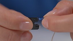 Changing a hearing aid ear wax filter with a wax removal tool