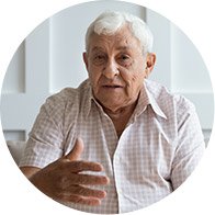 Elderly man gesturing while speaking indoors
