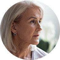 Woman with gray hair looking away, showing concern or discomfort.