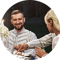 Smiling man enjoying an outdoor dinner with a woman.