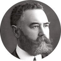 Founder of Oticon wearing a suit and tie in a black-and-white portrait with a blurred face.