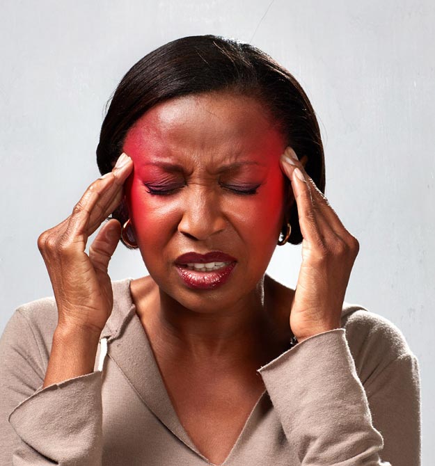 Woman experiencing discomfort, touching her temples with a red hue on her forehead.