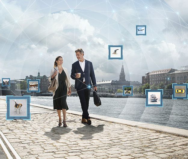 Couple walking by the harbor surrounded by visual representations of highlighted environmental sounds, including a dog, birds, and a plane.