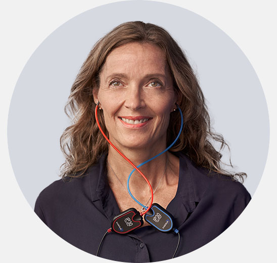 Woman undergoing a hearing assessment wearing diagnostic equipment with red and blue earpieces.