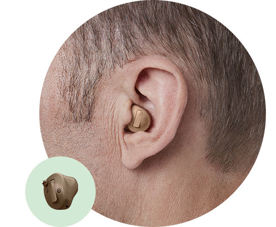 In-the-ear half shell hearing aid placed securely in a person’s ear.
