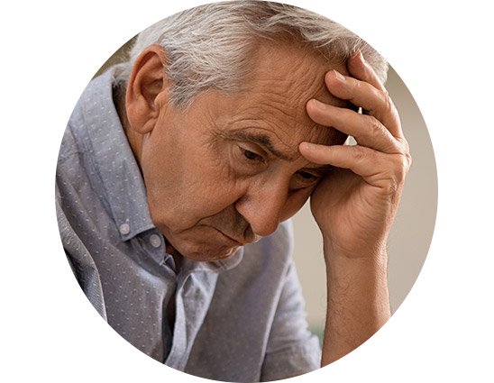 Man with gray hair holding his hand to the side of his head, appearing thoughtful or concerned.
