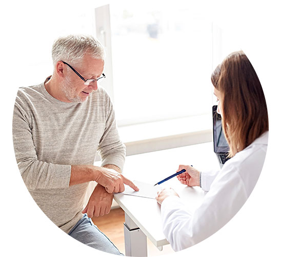 Man consulting with hearing care professional while reviewing a document