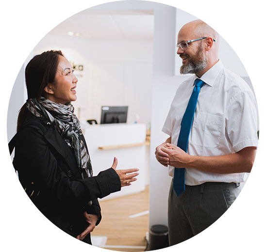 Woman consulting with an audiologist in a clinic reception area.